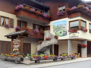 a building with flowers on the side of it at Hotel Corona in Branzi