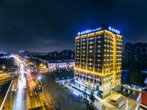 un edificio illuminato su una strada cittadina di notte di Atour Hotel (Shanghai International Tourism and Resorts Zone XiuYan Road) a Shanghai