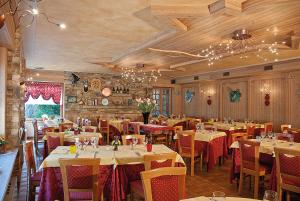 restauracja ze stołami i krzesłami w pokoju w obiekcie Hotel Corona w mieście Branzi