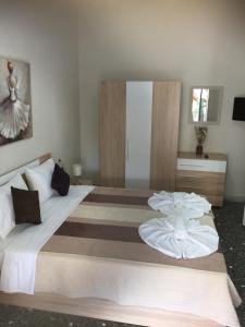 a bedroom with a large bed with white sheets at Periklis House in Nea Kalikratia
