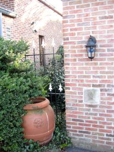 un mur en briques avec un grand vase à côté d'un bâtiment dans l'établissement Hotel Plaza, à Lommel