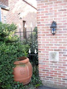 a brick wall with a large vase next to a building at Hotel Plaza in Lommel