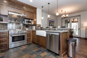 a large kitchen with wooden cabinets and stainless steel appliances at Woodwinds 25 in Mammoth Lakes