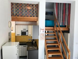 una piccola cucina con scala che conduce a un soppalco di Lime Apartments - LIDO ad Alghero