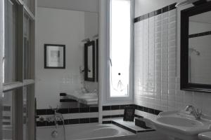 a black and white bathroom with two sinks and a tub at Villa Vesone in Périgueux