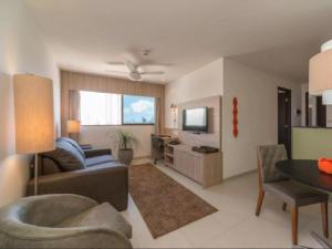 uma sala de estar com um sofá e uma mesa em Excelente Flat em Boa Viagem 2 quartos Beach Class Ideal para Família ou Viagens de Negócio NOB1804 no Recife