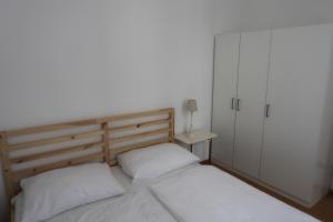 1 dormitorio con 2 camas blancas y armario en Casa Nostra - Ruhige Stadtwohnung mit Balkon, en Viena