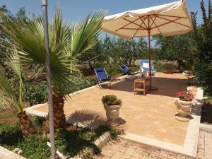 patio con ombrellone, sedie e tavolo di Villa Calendula a Corato