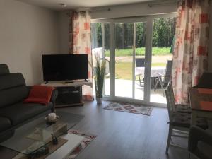 a living room with a couch and a television at Ferienwohnung Zweisamkeit in Graal-Müritz