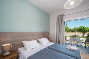 a bedroom with a large bed and a balcony at Villaggio Verde in Laganas