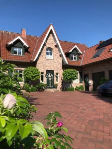 uma grande casa de tijolos com uma entrada em Ferienwohnung Landart em Hilter