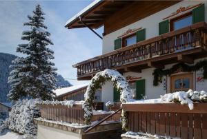 a house in the snow with a christmas tree at Landhof in Monguelfo