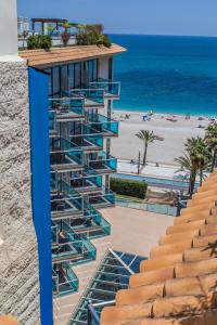 a building with stairs leading to the beach at KAKTUS Hotel Kaktus Albir in Albir