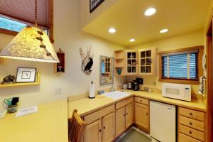 a kitchen with a sink and a microwave at Crow Creek in Girdwood