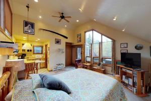 a bedroom with a large bed and a kitchen at Crow Creek in Girdwood
