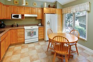 a kitchen with wooden cabinets and a table and chairs at Summerwind Cottage 1140 in Seabrook Island