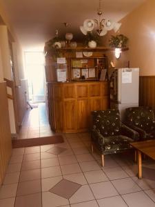 a living room with two chairs and a refrigerator at Rózsakert Panzió in Nyíregyháza