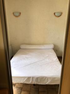 コトレにあるResidence Courbet Meylougaの白いシーツが備わる小さな部屋の小さなベッド1台分です。