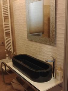 a bathroom with a black sink and a mirror at Diadumeno Great Apartment in Venosa