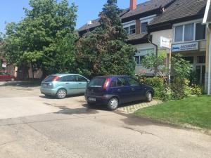 two cars parked in the driveway of a house at Rózsakert Panzió in Nyíregyháza
