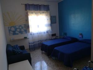 a bedroom with two beds and a couch and a window at Le Terrazze in Carini