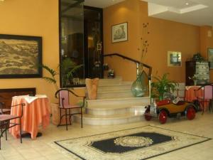 ein Wohnzimmer mit einer Treppe mit einem Tisch und Stühlen in der Unterkunft Hotel Ambasciatori in Calitri
