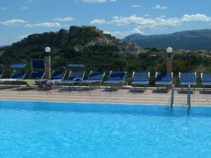 a row of blue lounge chairs next to a swimming pool at Hotel Ambasciatori in Calitri