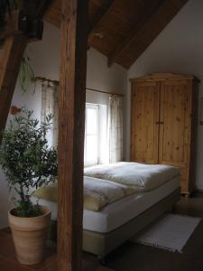 a bedroom with a bed and a wooden cabinet at Apartments Bed & Breakfast Brückner in Willanzheim