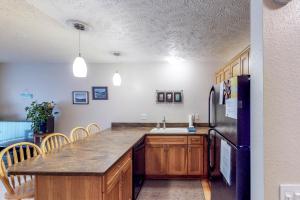 a kitchen with a black refrigerator and a sink at Brighton Condo #209 in Girdwood