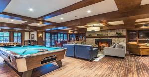 a living room with a pool table and a fireplace at Château Beauvallon in Mont-Tremblant