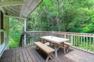 una terraza de madera con mesa y bancos. en Downtown Cottage in the Woods, en Guerneville