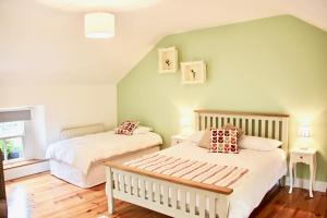 two beds in a bedroom with green walls and wooden floors at Riverside House in Newport