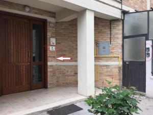 an open door of a brick building with an arrow pointing to a building at Itaka in LʼAquila