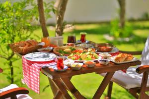 a picnic table with food and drinks on it at Alacati Sorf Hotel in Alaçatı
