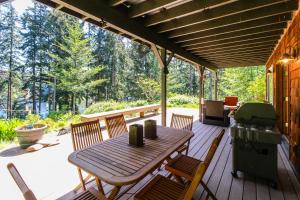 une terrasse avec une table, des chaises et un grill dans l'établissement Goss Lake Getaway, à Langley