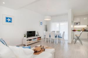 エリセイラにあるEriceira T2 Navegantes Apartmentの白いリビングルーム(白いソファ、テーブル付)