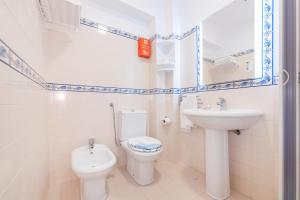 a white bathroom with a toilet and a sink at Ericeira T1 Navegantes Apartment in Ericeira +24 photos