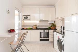 cocina blanca con armarios blancos y lavavajillas en Ericeira T2 Navegantes Apartment, en Ericeira
