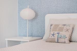 a bedroom with a bed with a lamp and a table at Ericeira T1 Navegantes Apartment in Ericeira