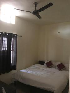 a bedroom with a bed with a ceiling fan at Hotel Dharohar Palace in Jaipur