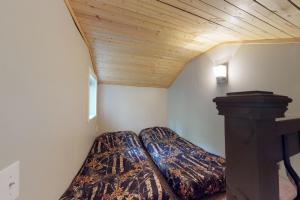 een slaapkamer met 2 bedden en een houten plafond bij Loveland Cottage in Girdwood