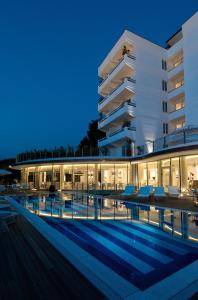 un hotel con piscina di fronte a un edificio di Mondial Resort & Spa a Marina di Pietrasanta
