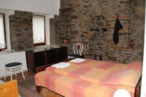 a bedroom with a bed and a stone wall at **ETNO Vila** - KRUSEVO in Kruševo
