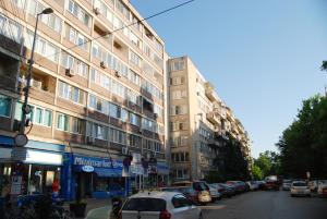 a city street with cars parked next to tall buildings at City Home Timisoara in Timişoara