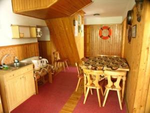 a kitchen with a stove and a table with chairs at Anker Kotwica in Łeba