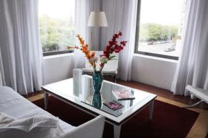a living room with a vase with flowers on a table at Residence Master Suite en Porteño Building in Buenos Aires