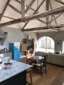 a kitchen and living room with a table and chairs at Hookcar Hill Cottage in Bedale