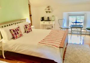 a bedroom with a large white bed with pillows at Riverside House in Newport