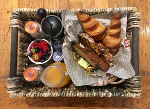 uma cesta de alimentos com bolos e frutas sobre uma mesa em Riverside House em Newport