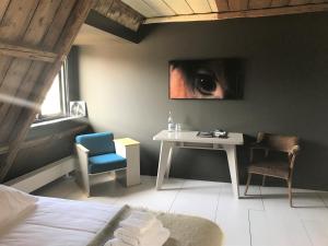 a bedroom with a table and chairs and a eye painting at Omke Jan in Woudsend